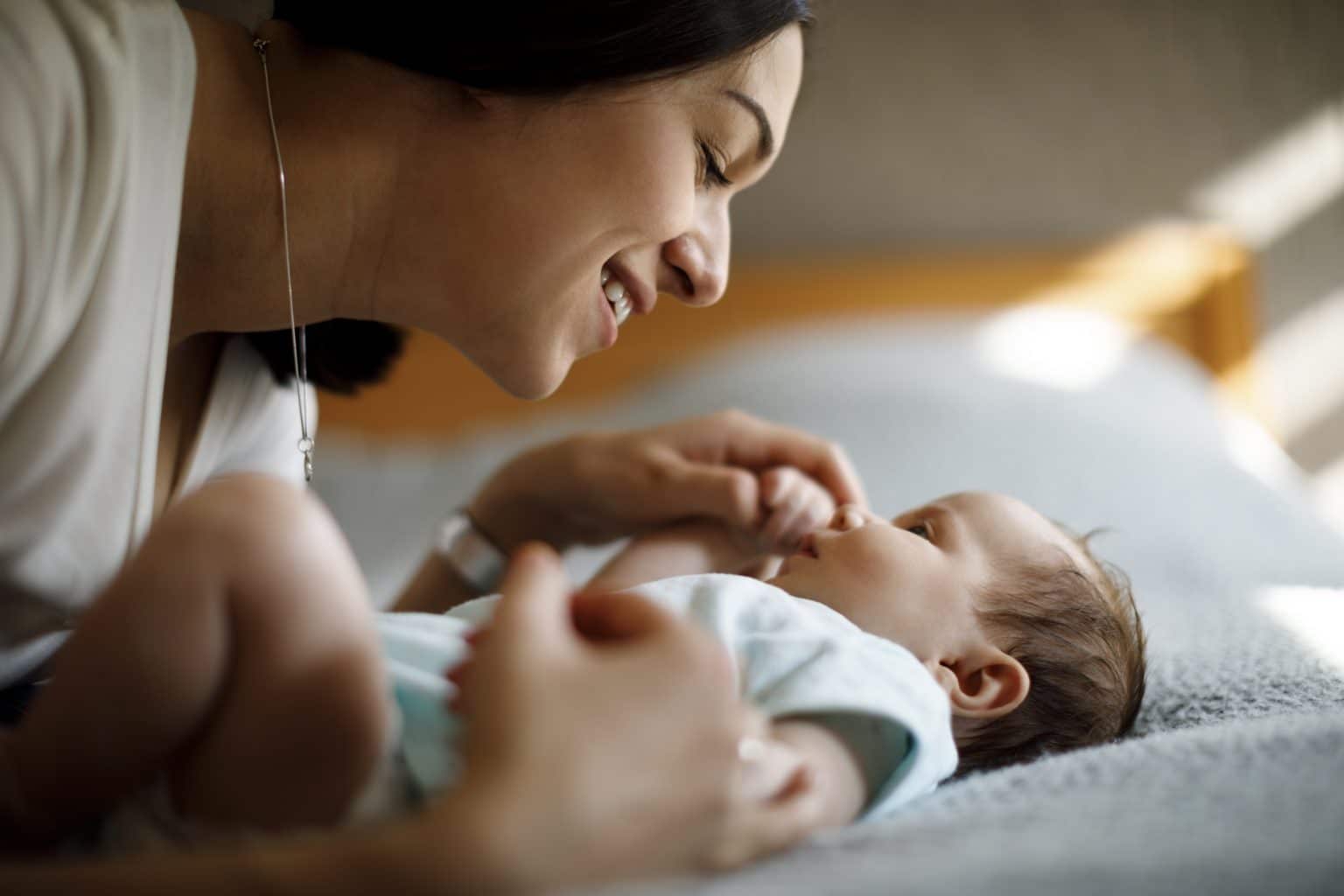 Pediatric Newborn Hearing Loss Woman holding hand of very small baby in a hospital room setting